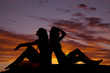 © Poulsons Photography - Silhouette two women sit back to back