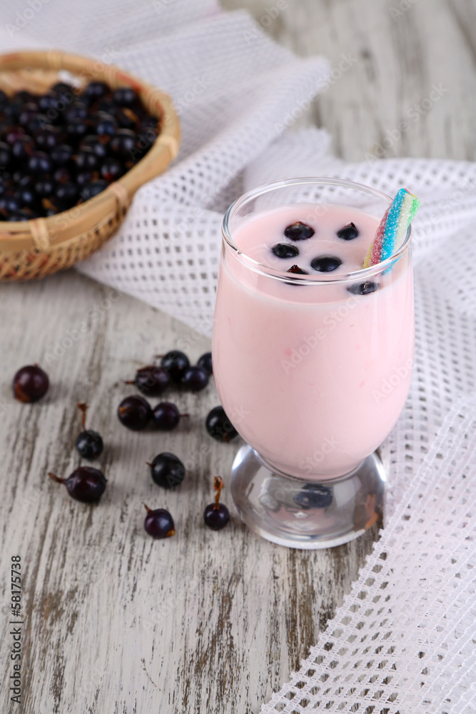 Delicious milk shake with blackberry on wooden table close-up
