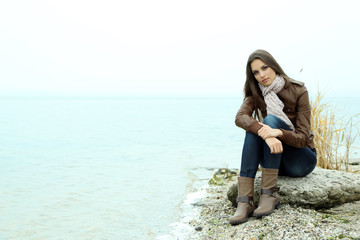 Wall Mural - Portrait of young serious woman near river