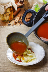 Canvas Print - Serving tomato soup. Pouring soup into a plate