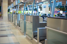 Row Of Empty Check-in Desks With Computers In Airport