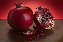 Fresh Fruit Pomegranate On A Wooden Table With A Red Background
