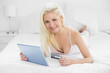 © lightwavemedia - Casual young blond doing online shopping in bed
