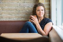 Woman With Coffee Mug Sitting In Cafeteria