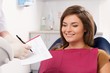 Beautiful young brunette woman visiting dentist