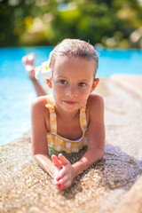 Adorable girl in the swimming pool with flower behind her ear