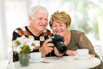 senior couple viewing pictures on camera