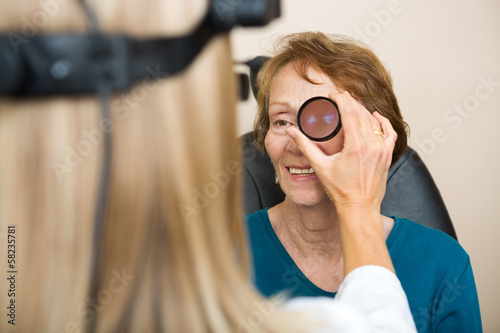 Cuadros en Lienzo Optician Examining Senior Woman's Eye