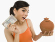 © imagedb.com - Woman holding Indian currency notes with a piggy bank