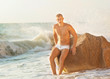 © Rock and Wasp - Fit worked-out man walking out of ocean onto beach with sky back