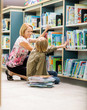 © Tyler Olson - Female Teacher And Boy Selecting Books In Library