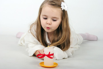 A beautiful little girl angel with a candle