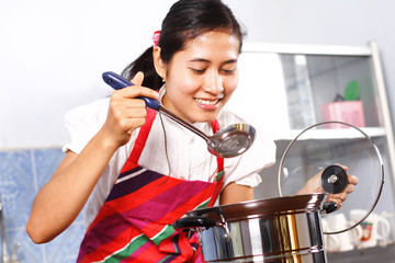 Asian woman tasting her cooking