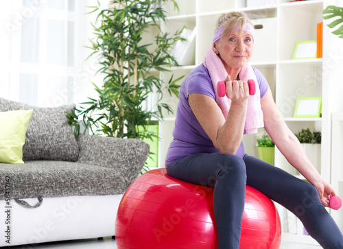 Foto Glückliche ältere Frau, die auf Gymnastikball und Übung sitzt
