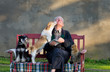 © Budimir Jevtic - Senior man with dogs and cat on his lap on bench