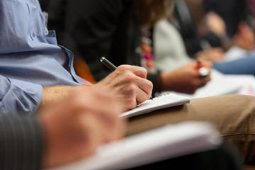 Making notes at conference, detail.