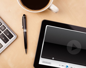 Wall Mural - tablet pc showing media player on screen with a cup of coffee on