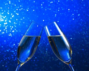 a pair of champagne flutes on blue light bokeh background