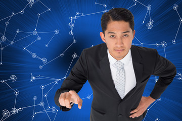 Poster - Composite image of unsmiling asian businessman pointing
