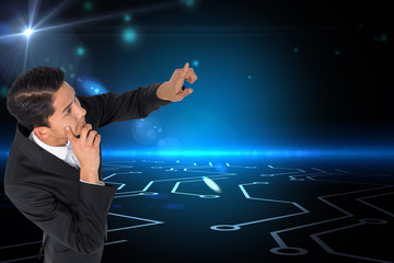 Poster - Composite image of thoughtful asian businessman pointing