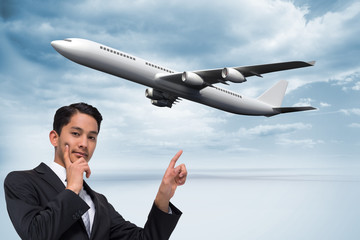Poster - Composite image of thoughtful asian businessman pointing