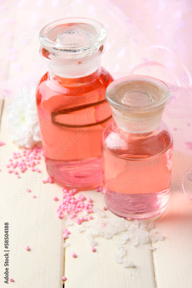 Glass bottles with color essence, on pink background
