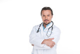 Fototapeta Na drzwi - Confident adult doctor standing on white background.