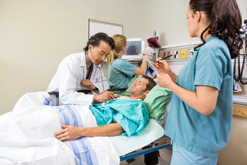 Wall Mural - Doctor And Nurses Examining Patient In Hospital