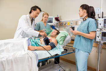 Wall Mural - Nurses And Doctor Examining Male Patient