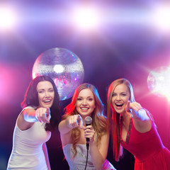 Canvas Print - three smiling women dancing and singing karaoke