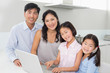 © lightwavemedia - Portrait of a family of four with laptop in kitchen