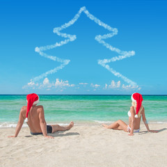 Sticker - Lovers couple in santa hats at tropical sandy beach - christmas