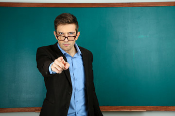 Wall Mural - Young teacher near chalkboard in school classroom