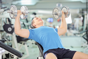 Sticker - Young muscular male lifting weights in a gym