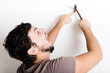 © Eugenio Marongiu - young man bricolage hammering nail wall