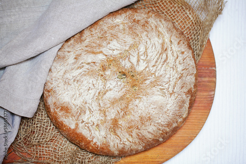 Fotografie, Obraz Rustic cornmeal and rye bread loaf, whole dusted with flour