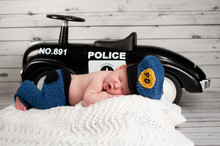 Newborn Baby Wearing A Policeman Costume