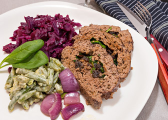 traditional european dinner of meatloaf, red cabbage and green b