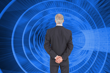 Poster - Composite image of rear view of serious businessman posing
