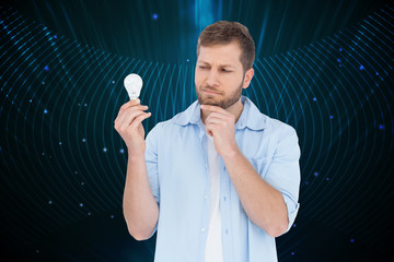 Poster - Composite image of sceptical model holding a bulb