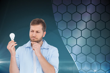 Poster - Composite image of sceptical model holding a bulb