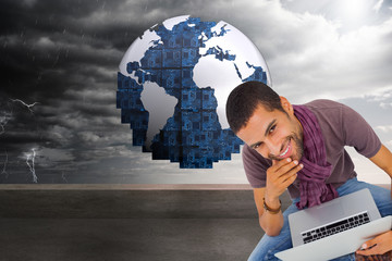 Poster - Composite image of thoughtful man sitting on floor using laptop