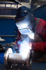 Wall Mural - Welder with protective mask welding metal and sparks