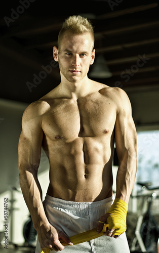 Foto-Leinwand ohne Rahmen - Muscular young man wrapping bandage around his hands (von theartofphoto)