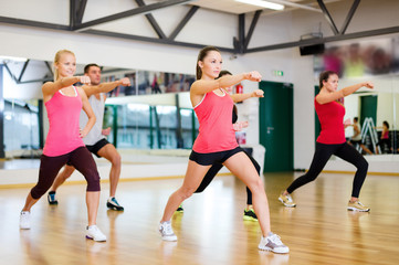 Poster - group of smiling people exercising in the gym