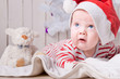 © golovianko - Cute baby in Santa`s hat with a teddy bear