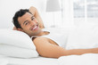 © lightwavemedia - Cheerful young man resting in bed