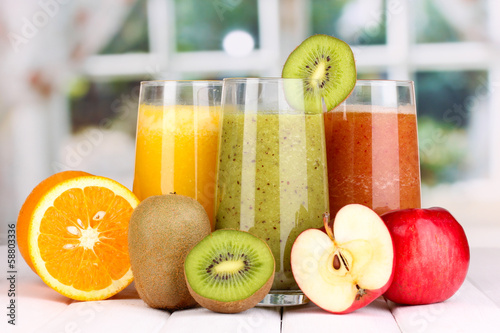 Fototapeta do kuchni fresh fruit juices on wooden table, on window background