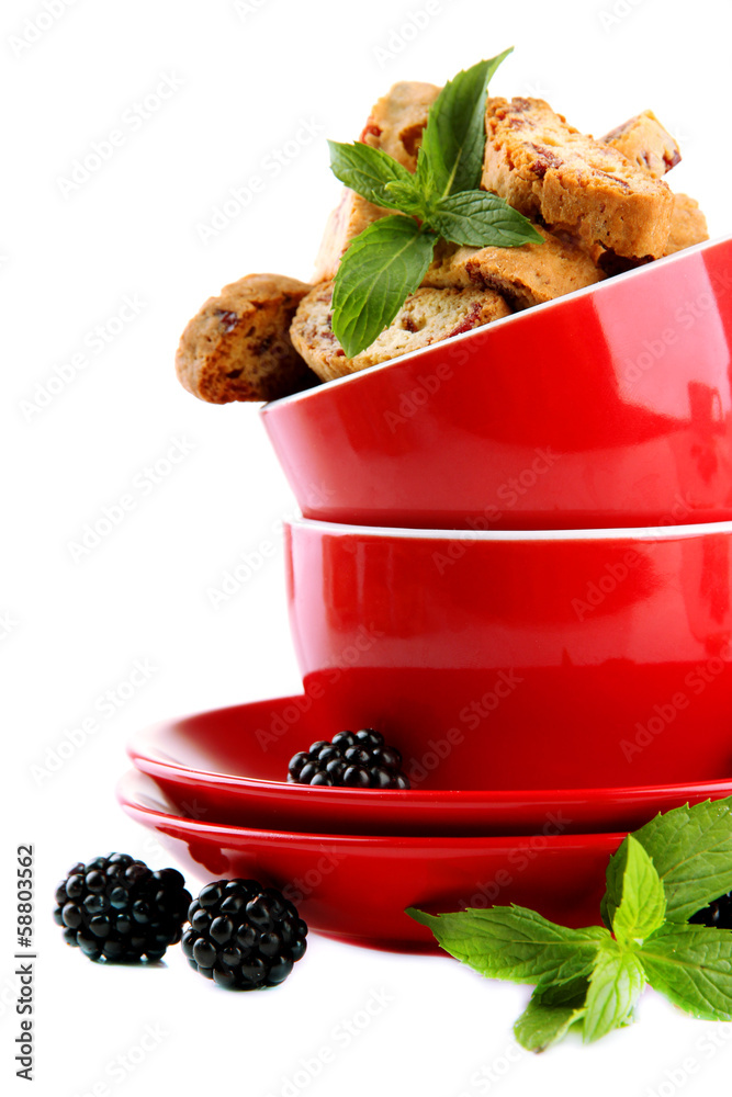 Tasty cookies with blackberry in cups isolated on white