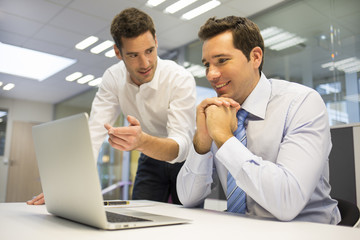 Two handsome businessmen working together on a laptop ,office